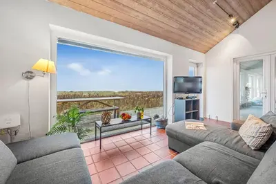 a living room with two couches and a large window at Pool And Activity House With A 180-Degree View Of The North Sea, Located At Lild Strand in Frøstrup