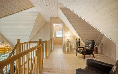 a living room with a chair and a staircase at Gorgeous Home In Blokhus With Sauna in Blokhus