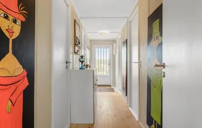 a hallway with paintings of women on the walls at Pet Friendly Home In Blokhus With Wifi in Blokhus