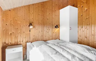 a bedroom with a white bed and wooden walls at Pet Friendly Home In Thisted With Sauna in Thisted