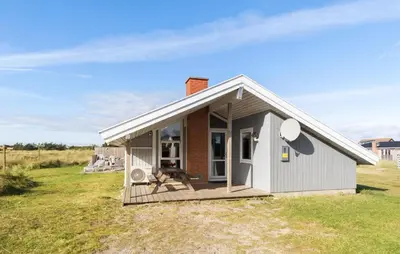 a small house with a porch on a field at Pet Friendly Home In Thisted With Sauna in Thisted