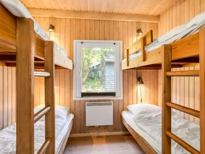 a room with three bunk beds and a window at Holiday Home Arild - 900m from the sea by Interhome in Saltum