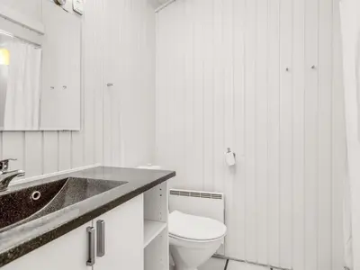 a white bathroom with a toilet and a sink at Holiday Home Arild - 900m from the sea by Interhome in Saltum