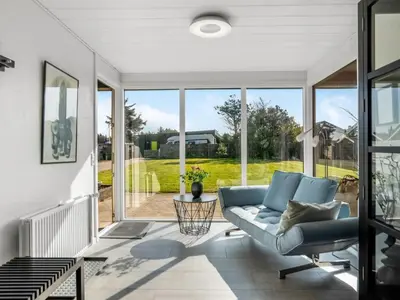 a living room with a couch and a large window at Holiday Home Isabel - 600m from the sea by Interhome in Blokhus