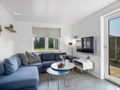 a living room with a blue couch and a table at Holiday Home Isabel - 600m from the sea by Interhome in Blokhus