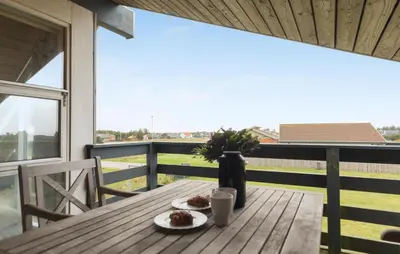 a wooden table with two plates of food on a balcony at Beautiful Home In Thisted With Sauna in Thisted