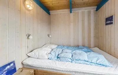 a bed in a room with wooden walls at Beautiful Home In Thisted With Sauna in Thisted