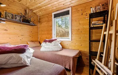 a room with two beds in a wooden cabin at 2 Bedroom Nice Home In Løgstør in Løgstør