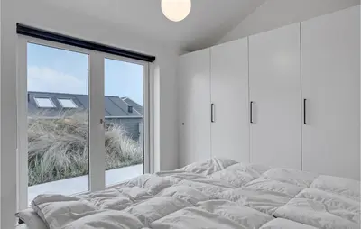 a bedroom with a bed and a large window at Five-Bedroom Holiday Home Løkken With A Room Hot Tub 04 in Løkken