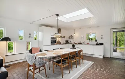 a kitchen and dining room with a table and chairs at Three-Bedroom Holiday Home Thyholm With A Fireplace 06 in Thyholm