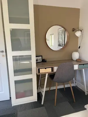 a room with a desk with a mirror and a chair at Aneks i rolige omgivelser-adgang til pool og sauna in Avlum