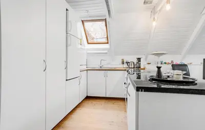 a kitchen with white cabinets and a black counter top at 3 Bedroom Lovely Home In Spøttrup in Spottrup