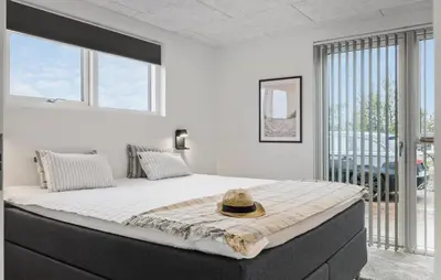 a bedroom with a large bed with a hat on it at Cozy Home In Saltum With Sauna in Saltum