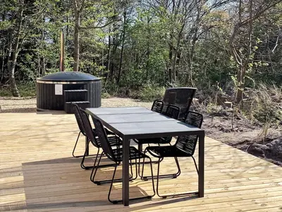 a table and chairs on a deck with a grill at 5 star holiday home in Vestervig-By Traum in Vestervig