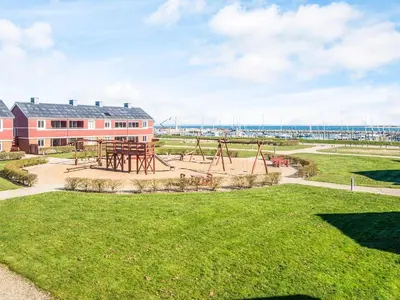 an empty park with a playground in front of a building at 4 person holiday home in Lemvig in Lemvig