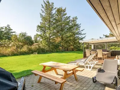 a patio with a wooden picnic table and chairs at Holiday Home Rajna - 500m to the fjord by Interhome in Vestervig