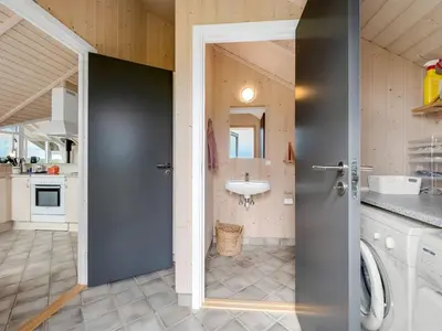 a bathroom with a sink and a door to a kitchen at Holiday Home Märta - 250m from the sea by Interhome in Lemvig