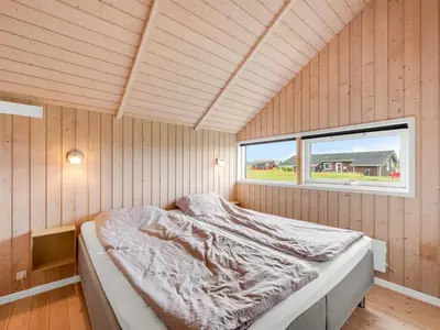a bed in a room with a window at Holiday Home Märta - 250m from the sea by Interhome in Lemvig