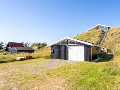 a house with a garage on the side of a hill at Holiday Home Naema - 400m from the sea by Interhome in Blokhus