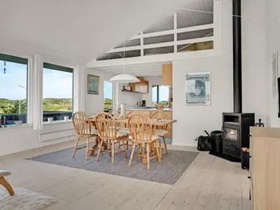 a kitchen and dining room with a table and chairs at Holiday Home Naema - 400m from the sea by Interhome in Blokhus