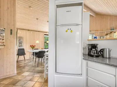 a white refrigerator in a kitchen with a table at Holiday Home Matthea - 900m from the sea by Interhome in Fjerritslev
