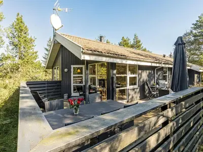 a house with a deck and an umbrella at Holiday Home Matthea - 900m from the sea by Interhome in Fjerritslev