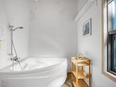 a bathroom with a large white tub in a room at Holiday Home Matthea - 900m from the sea by Interhome in Fjerritslev