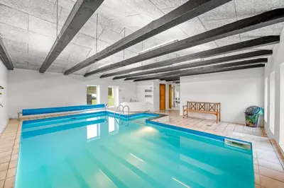 an indoor pool with blue water in a building at Large Pool House With Activity Room Located In Peaceful Surroundings in Frøstrup