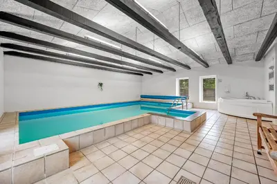 a swimming pool in a room with a tub at Large Pool House With Activity Room Located In Peaceful Surroundings in Frøstrup