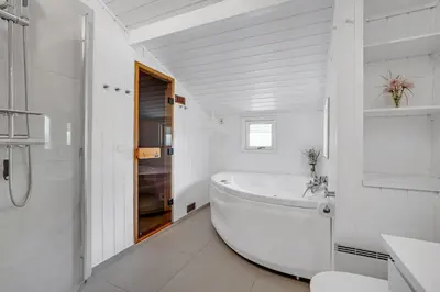 a white bathroom with a tub and a sink at Lovely Spa House In Scenic Surroundings in Thyholm