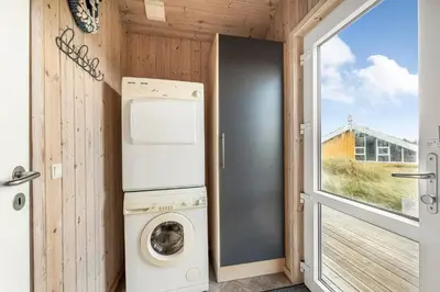 a washer and dryer in a tiny house at Holiday Home With Spa And Sauna, Just 200 Meters From The North Sea in Frøstrup