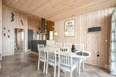 a kitchen and dining room with a table and chairs at Holiday Home With Spa And Sauna, Just 200 Meters From The North Sea in Frøstrup
