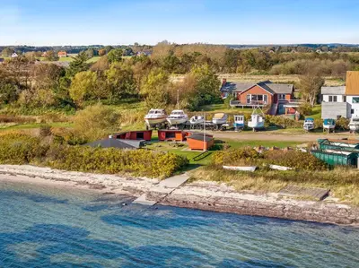 an aerial view of a house next to a body of water at Large Holiday Home With A View Of The Fjord in Thyholm