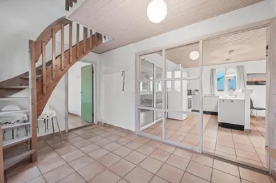 a large room with a staircase and a room with a desk at Pool And Activity House With A Fantastic View Of The North Sea in Frøstrup