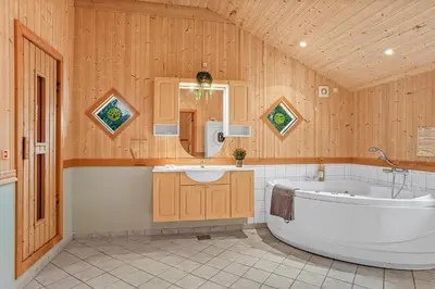 a large bathroom with a tub and a sink at Cozy And Spacious Holiday Home Near Torup Strand Close To The North Sea in Fjerritslev