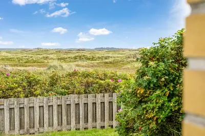 a fence in front of a field of flowers at Lovely Holiday Home With Panoramic Views Of The North Sea in Frøstrup