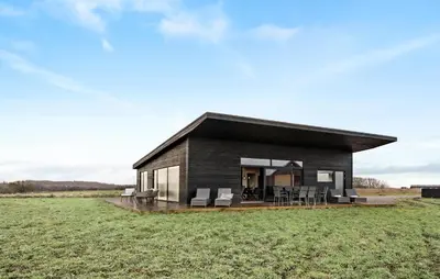 a black house on a grassy field at 3 Bedroom Stunning Home In Løgstrup in Løgstrup