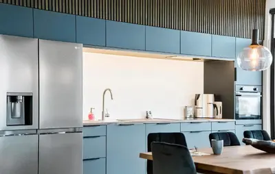 a kitchen with blue cabinets and a wooden table at 3 Bedroom Stunning Home In Løgstrup in Løgstrup