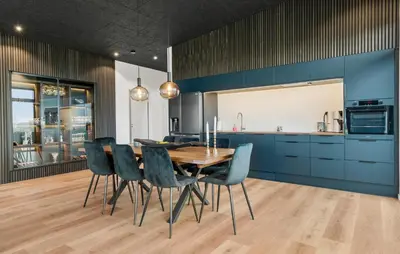 a dining room with a wooden table and blue cabinets at 3 Bedroom Stunning Home In Løgstrup in Løgstrup