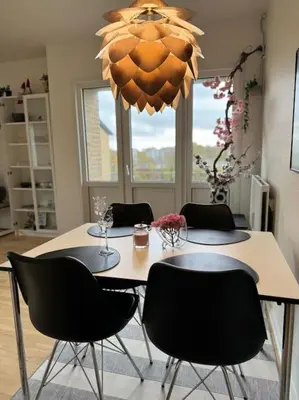 a dining room table with chairs and a chandelier at Stor og Lys Lejlighed i Hjertet af Holstebro in Holstebro