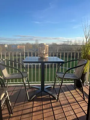 a table and chairs on a deck with a view at Stor og Lys Lejlighed i Hjertet af Holstebro in Holstebro