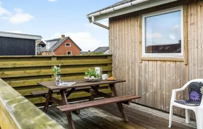 a wooden table on the deck of a house at 2 Bedroom Cozy Home In Thisted in Thisted