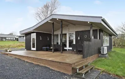 a small house with a wooden deck at 3 Bedroom Nice Home In Roslev in Roslev