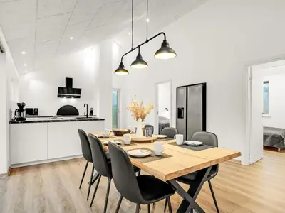 a kitchen and dining room with a wooden table and chairs at Holiday Home Grimar - 400m to the fjord by Interhome in Vemb