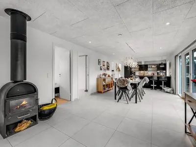 a living room with a fireplace and a dining room at Holiday Home Elisaveta - 400m to the fjord by Interhome in Vemb