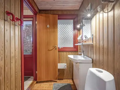 a bathroom with a white sink and a red door at Holiday Home Ennignup - 600m to the fjord by Interhome in Højslev