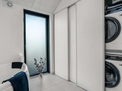 a laundry room with a window and washing machines at Holiday Home Stenkil - 1-2km from the sea by Interhome in Løkken