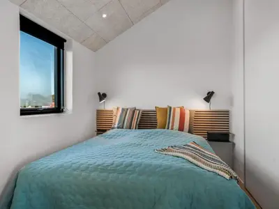 a bedroom with a bed and a window at Holiday Home Stenkil - 1-2km from the sea by Interhome in Løkken
