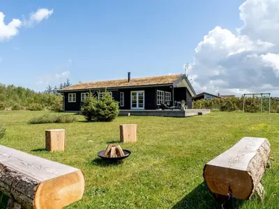 a house with a fire pit in the yard at Holiday Home Ljupco - 950m from the sea by Interhome in Saltum