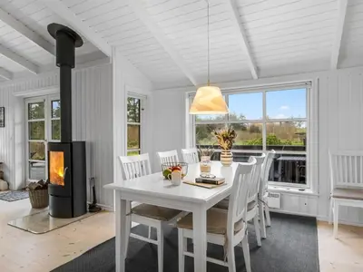 a white dining room with a white table and chairs at Holiday Home Ljupco - 950m from the sea by Interhome in Saltum